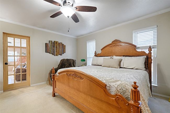 Carpeted bedroom featuring ceiling fan and ornamental molding | Image 23