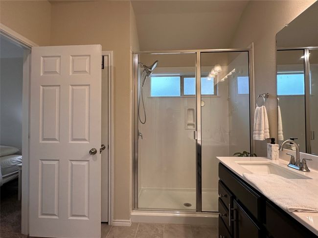 Bathroom with a stall shower, double vanity, and tile patterned flooring | Image 34