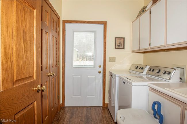 Washroom with cabinet space, independent washer and dryer, and dark wood finished floors | Image 12