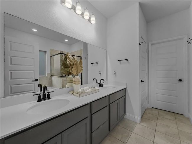 Full bath with a shower, tile patterned floors, double vanity, and recessed lighting | Image 12