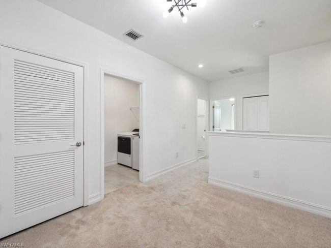 Spare room featuring light colored carpet and washer and clothes dryer | Image 15