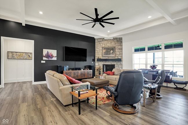living area with wood finished floors, beam ceiling, and ceiling fan | Image 9
