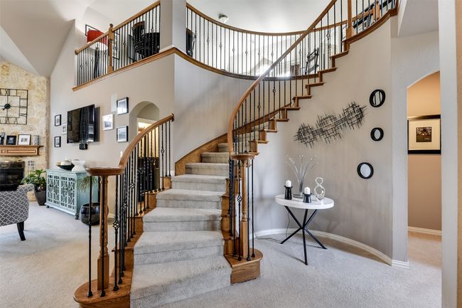 Stairway with a towering ceiling and carpet floors | Image 13