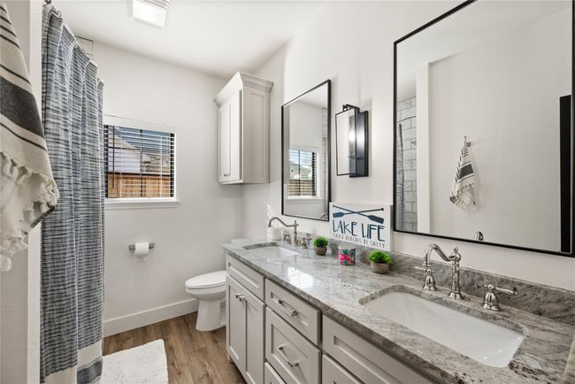 Full bathroom featuring wood finished floors, plenty of natural light, and double vanity | Image 30