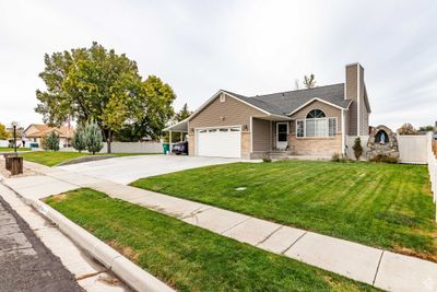 Ranch-style house featuring a garage and a front lawn | Image 1