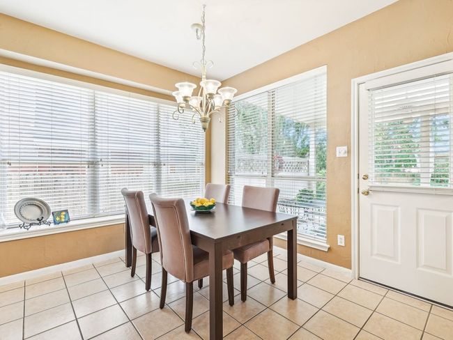 Dining room featuring a chandelier, baseboards, healthy amount of natural light, and light tile patterned flooring | Image 9