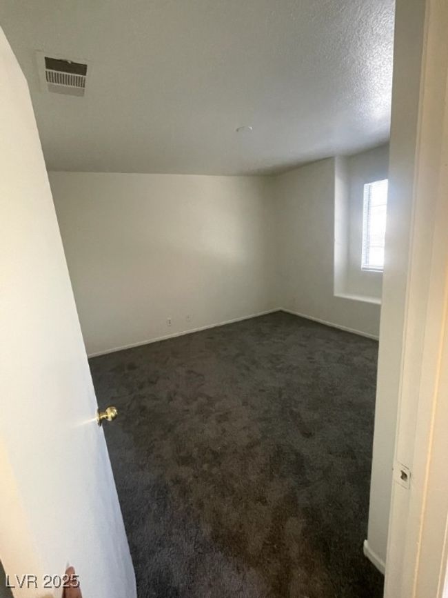 Spare room with baseboards, visible vents, dark carpet, and a textured ceiling | Image 18