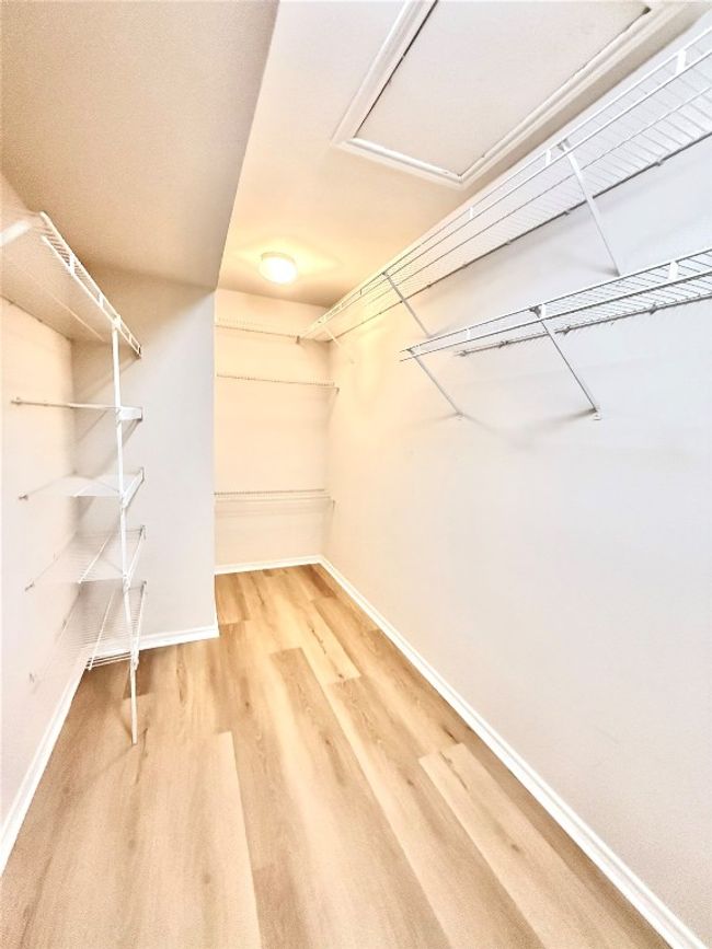 Walk in closet with light wood-type flooring and attic access | Image 9