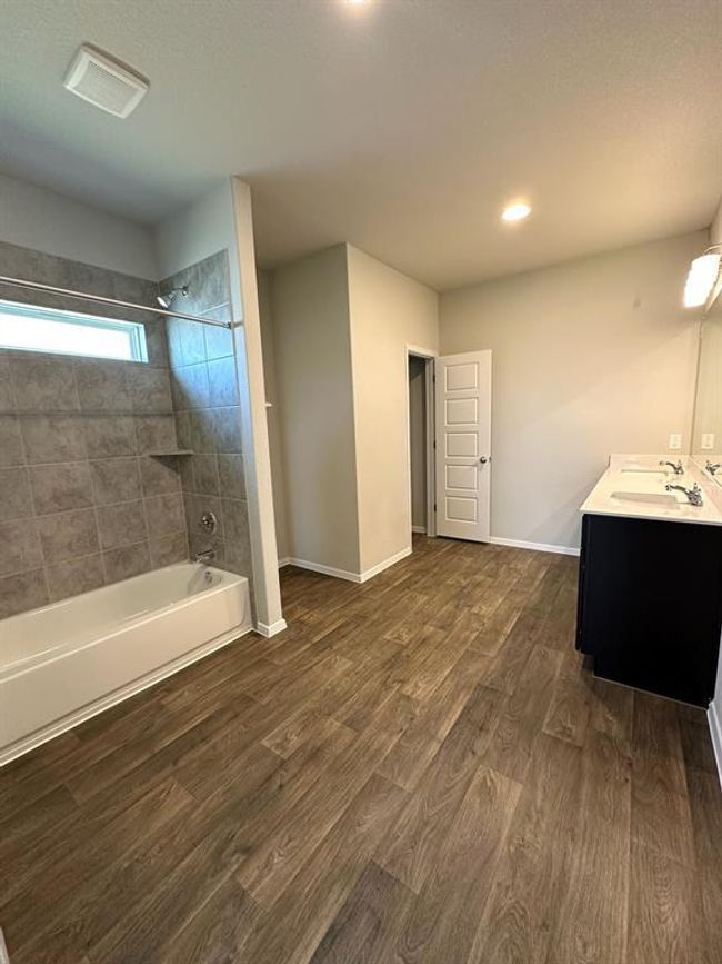 Bathroom featuring vanity, baseboards, wood finished floors, shower / washtub combination, and recessed lighting | Image 11