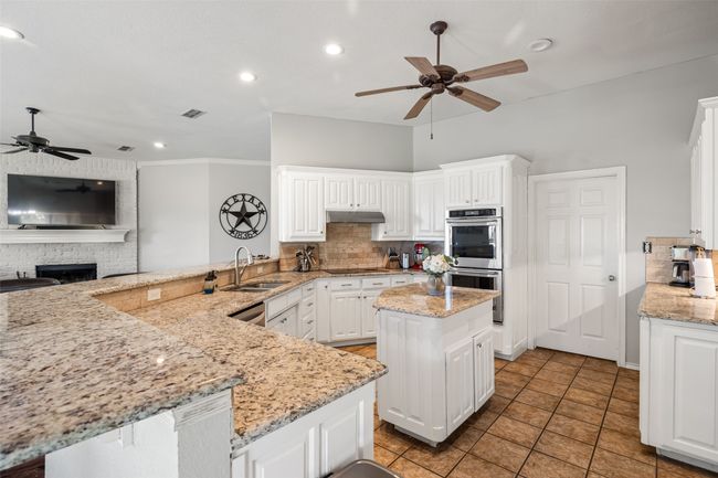 Kitchen featuring under cabinet range hood, appliances with stainless steel finishes, ceiling fan, and a sink | Image 11