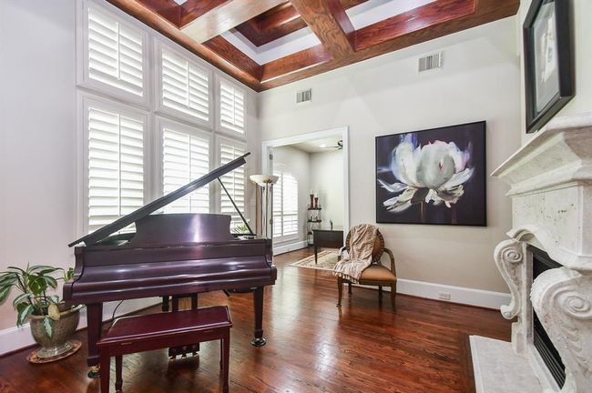 The Formal Living room greets you with a phenomenal cast stone fireplace, contrasting tray ceiling that adds depth and interest to timeless decor. | Image 11
