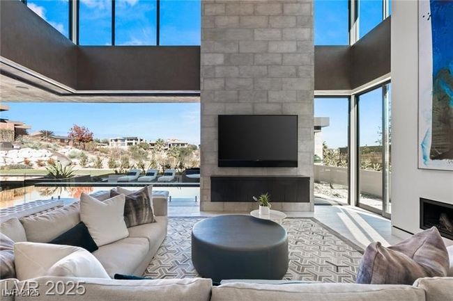 Living room featuring a high ceiling and a fireplace | Image 15