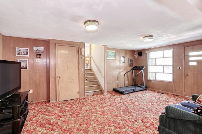 Exercise room with baseboards, wood walls, and carpet | Image 25