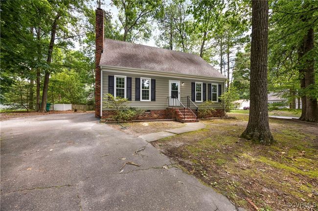 View of front of house with a chimney, asphalt driveway, and a shingled roof | Image 26