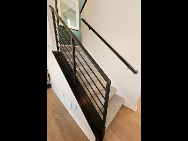 The sleek railing gracefully guides you to the upper level, adding a touch of modern elegance while enhancing the open, airy feel of the home. | Image 18