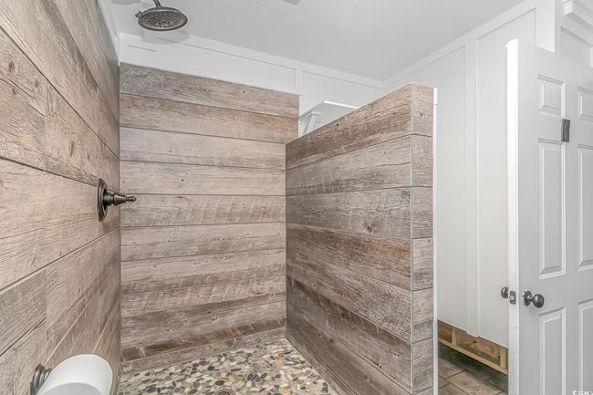 Full bath featuring a tile shower and wooden walls | Image 28