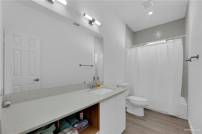 Full bathroom featuring vanity, toilet, wood-type flooring, and shower / tub combo with curtain | Image 19