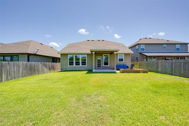 Back of property featuring a fenced backyard, a patio area, an outdoor living space, and roof with shingles | Image 25