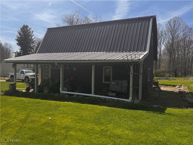 Back of property featuring a yard and metal roof | Image 6