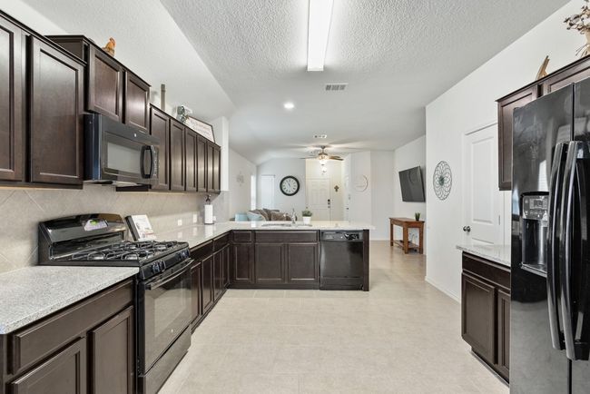 The kitchen offers a breakfast bar perfect for stools, granite countertops, lots of cabinet and work space, and a great dining area! | Image 8