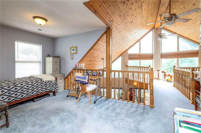 Carpeted bedroom featuring multiple windows and vaulted ceiling | Image 22