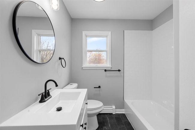 Bathroom featuring vanity, toilet, baseboard heating, and baseboards | Image 27