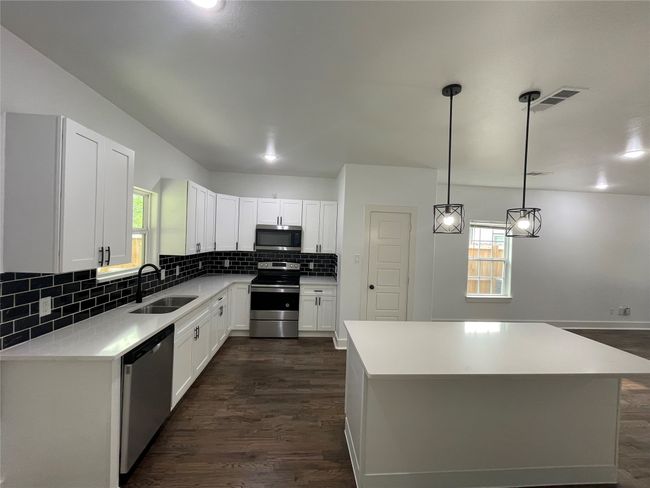 Kitchen with stainless steel appliances, a sink, dark wood finished floors, and plenty of natural light | Image 15