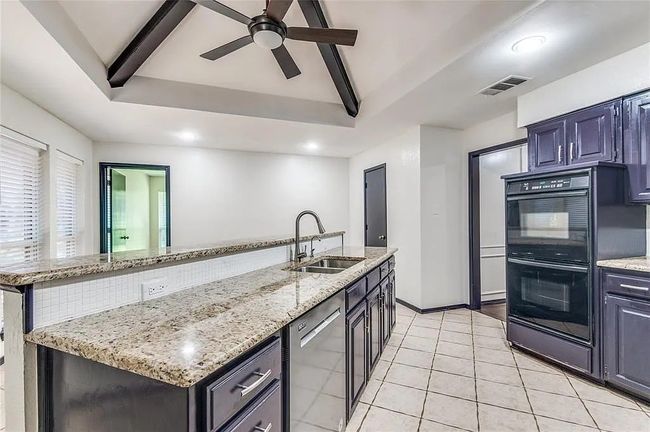 Kitchen featuring dobule oven black, a sink, visible vents, stainless steel dishwasher, and beam ceiling | Image 12