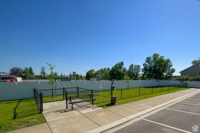 Surrounding community with a gate, a yard, uncovered parking, and fence | Image 18