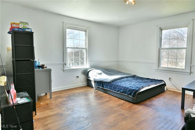 Bedroom with wood-type flooring, baseboards, and multiple windows | Image 33