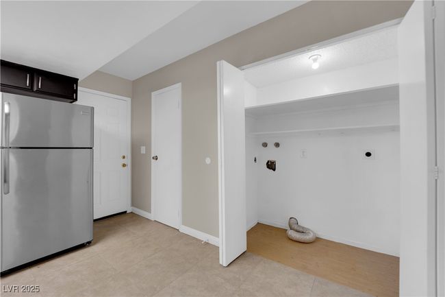 Washroom featuring electric dryer hookup, hookup for a washing machine, light tile patterned flooring, and baseboards | Image 12