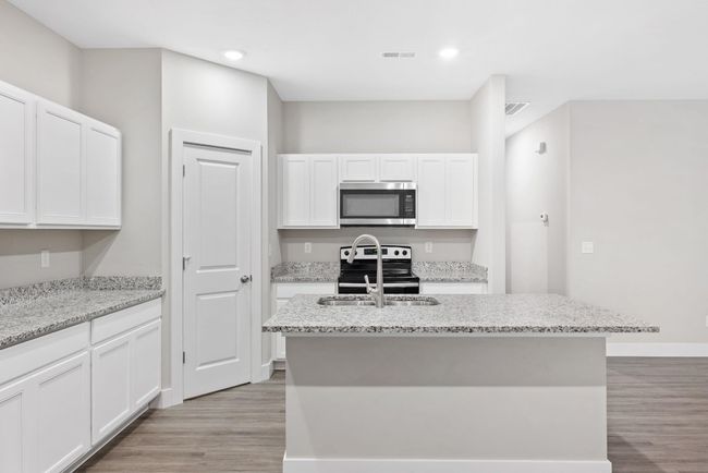 Kitchen featuring stainless steel appliances, light wood-type flooring, white cabinetry, and recessed lighting | Image 13