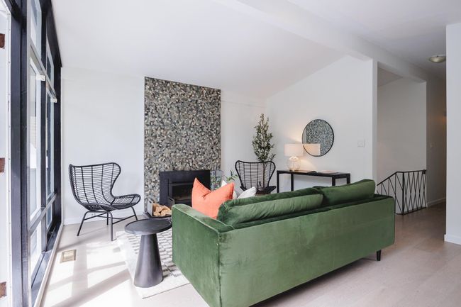 Living area with wood finished floors and a fireplace | Image 9