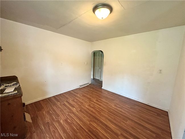 Unfurnished room featuring arched walkways, wood finished floors, visible vents, and baseboards | Image 15