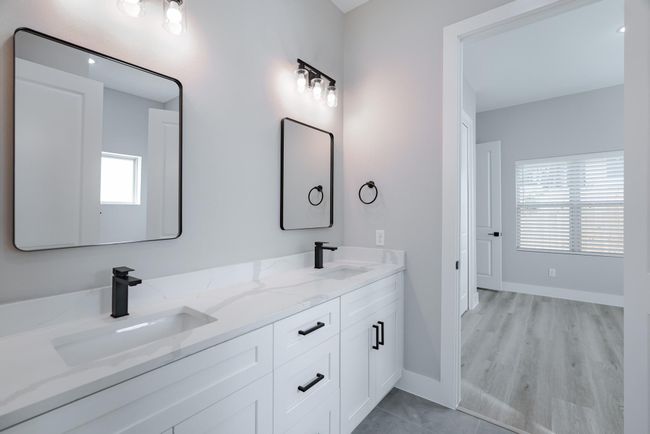 Secondary bathroom with double sinks and sleek walk-in shower | Image 30