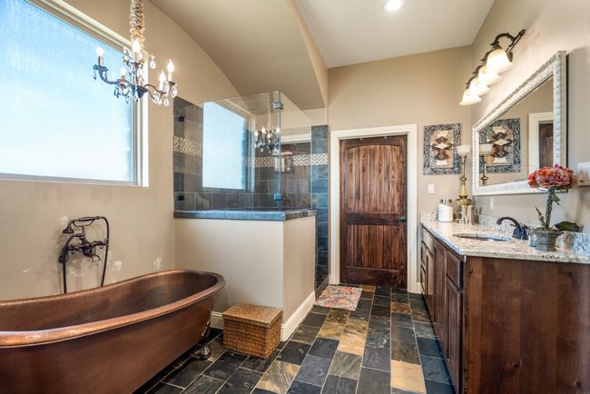 Bathroom with a chandelier, vanity, a walk in shower, and a freestanding tub | Image 22