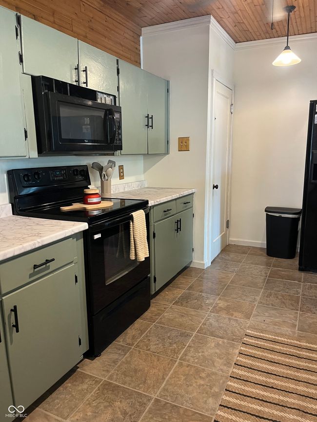 kitchen featuring black appliances, wooden ceiling, ornamental molding, baseboards, and light countertops | Image 16