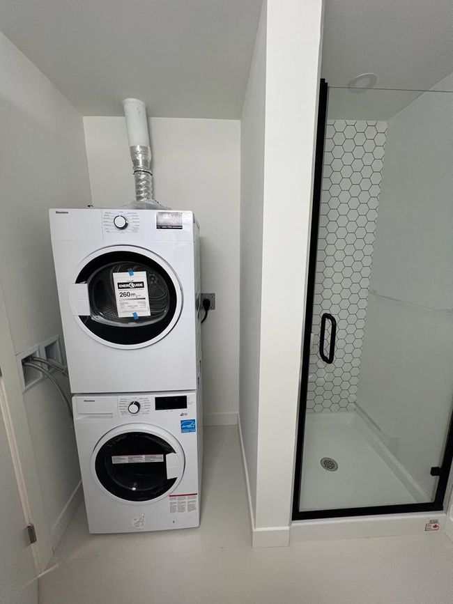 Washroom featuring baseboards, stacked washing maching and dryer, and laundry area | Image 8