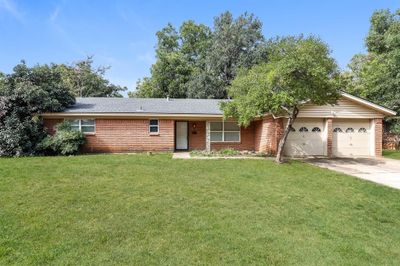 Single story home with a garage and a front lawn | Image 1