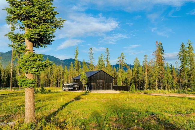 View of yard with a mountain view, an outbuilding, a detached garage, an outdoor structure, and a wooded view | Image 55
