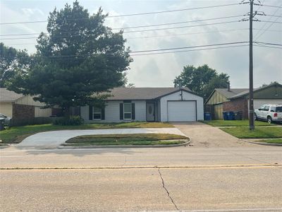 Ranch-style home featuring a garage and a front lawn | Image 1