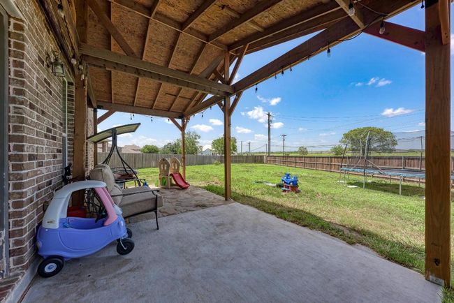 Fenced backyard with a trampoline and a patio | Image 30