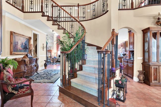 This magnificent stairway greets you and your guests as they enter the front door! Elegantly sweeping to the second floor with wrought iron balusters that allow light from the living room shine through. | Image 5