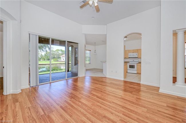 Unfurnished living room with ceiling fan, decorative columns, and light hardwood / wood-style flooring | Image 22