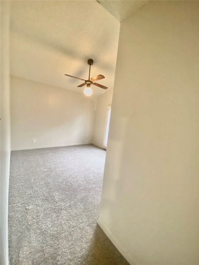 Spare room featuring a ceiling fan, carpet flooring, lofted ceiling, and baseboards | Image 6