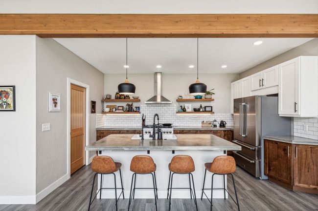 Kitchen with open shelves, wall chimney range hood, high end fridge, dark wood-style floors, and recessed lighting | Image 19