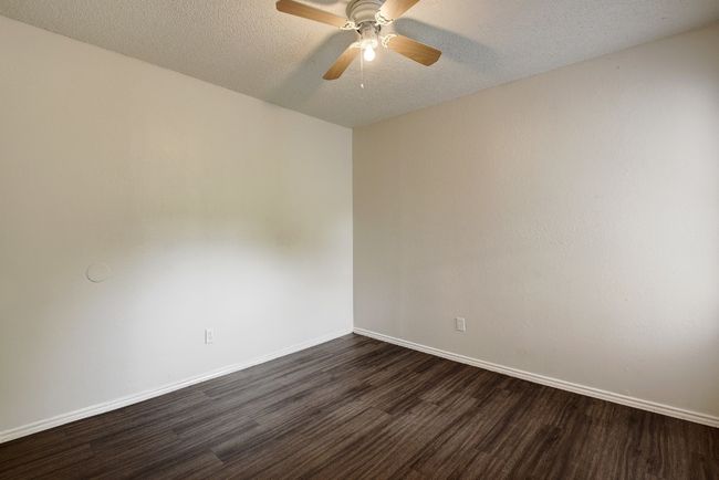 Spare room with dark wood finished floors, ceiling fan, baseboards, and a textured ceiling | Image 17