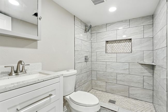 Full bathroom featuring a tile shower, vanity, and recessed lighting | Image 4