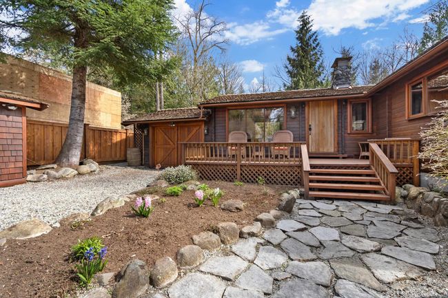 Rear view of house with a wooden deck and a chimney | Image 38