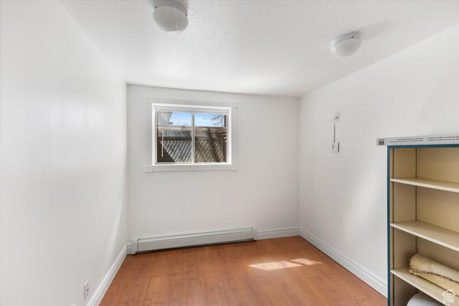 Empty room featuring baseboard heating, baseboards, and wood finished floors | Image 30
